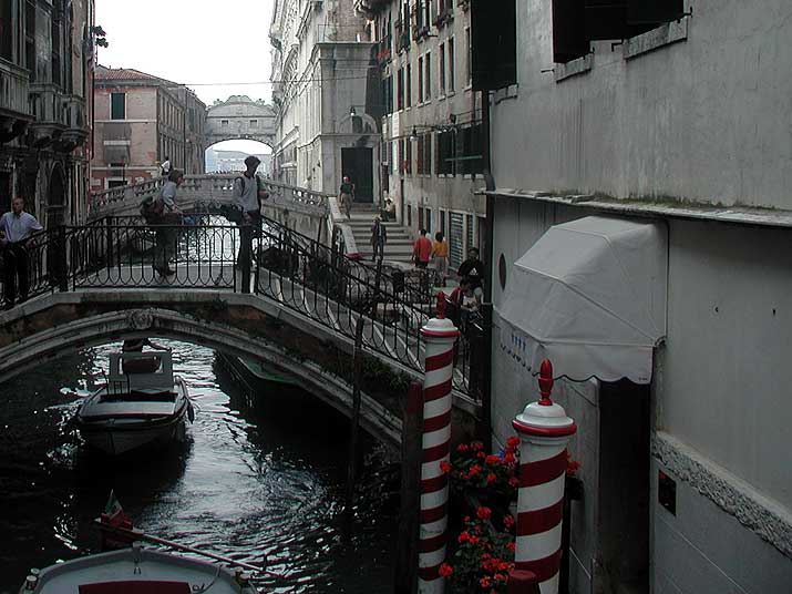 A view from a bridge over a canal in Venice, with the Bridge of Sighs in the distance